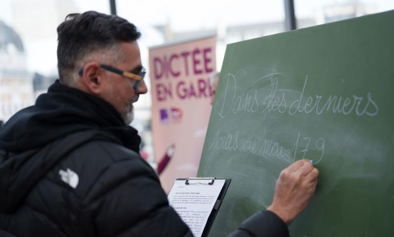 Rachid Santaki écrivant à la craie sur un tableau