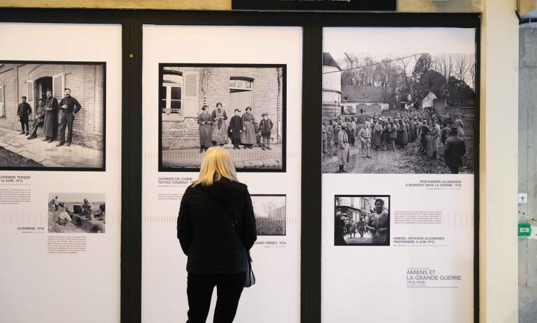 Photo d&#039;une voyageuse blonde en train de regarder les panneaux de l&#039;exposition &quot;Amiens dans la Première Guerre Mondiale&quot;