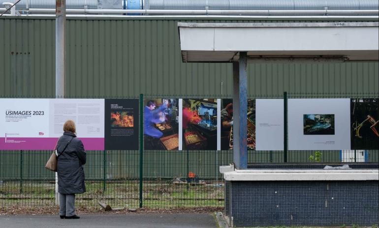 Voyageuse qui observe les panneaux de l&#039;exposition Usimages en gare de Liancourt Rantigny