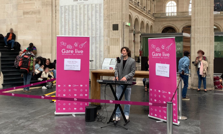 Étienne Perrier s'est produit en direct à la Gare de l'Est lors de l'événement Gare Live, enchantant les voyageurs avec un mélange de ballades pop et de morceaux célèbres.