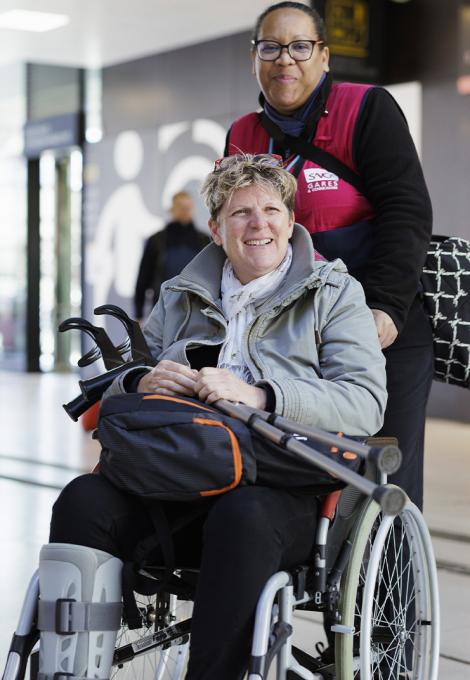 Agent SNCF assistant une personne en fauteuil roulant