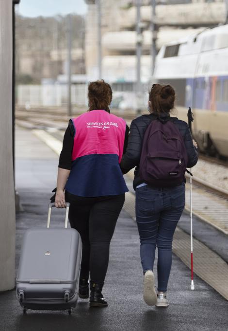 Agent SNCF assistant une personne non-voyante